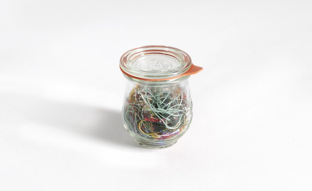 Jar preserving remnant threads from Lucie's mother's embroidery tin