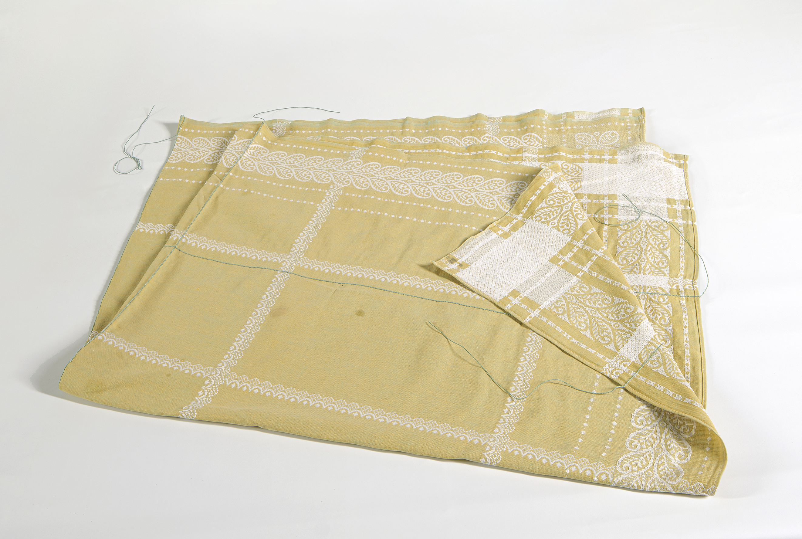 stained yellow cloth with added stitch lines